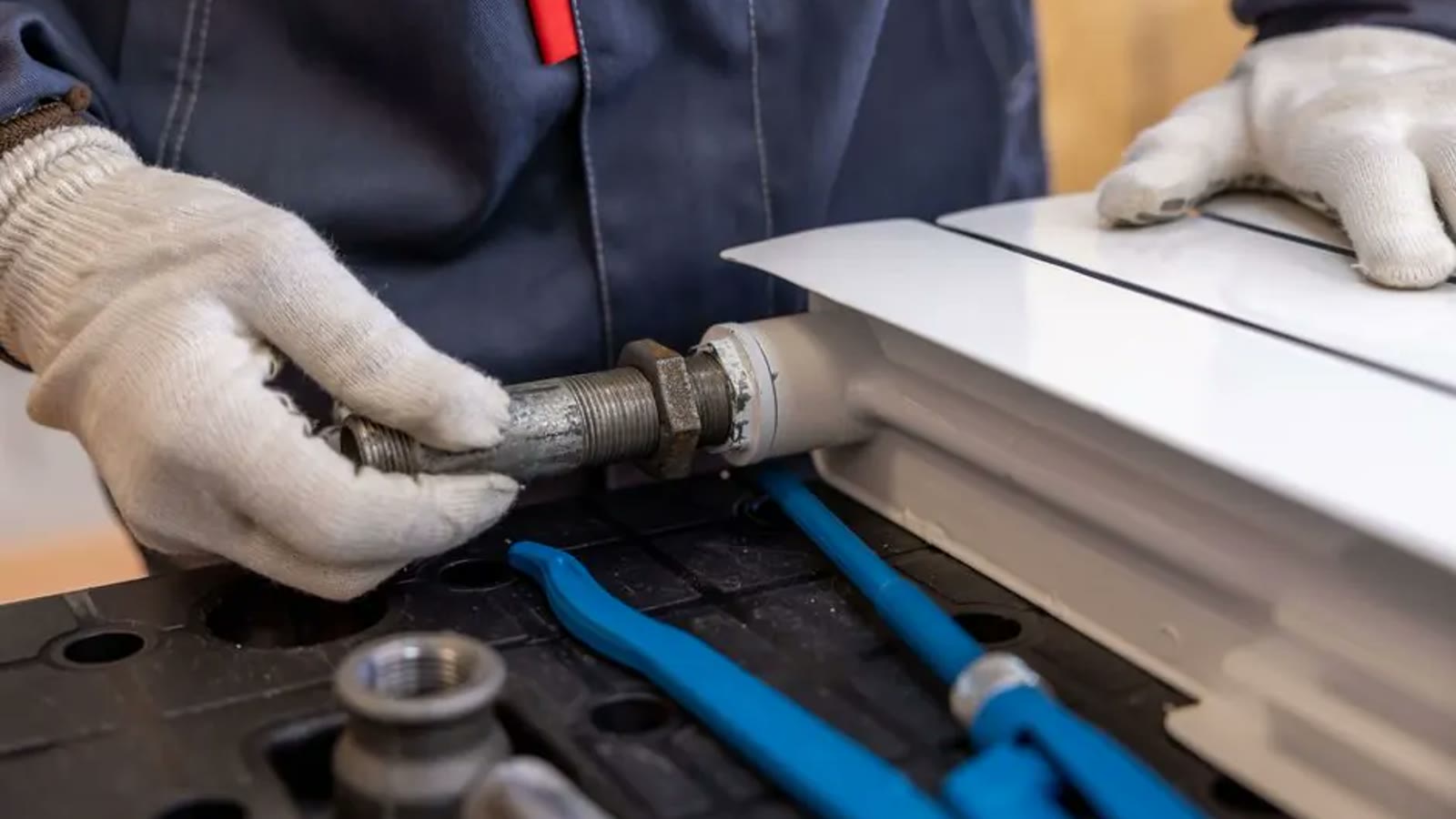Wrenches positioned on a threaded metal plumbing connection